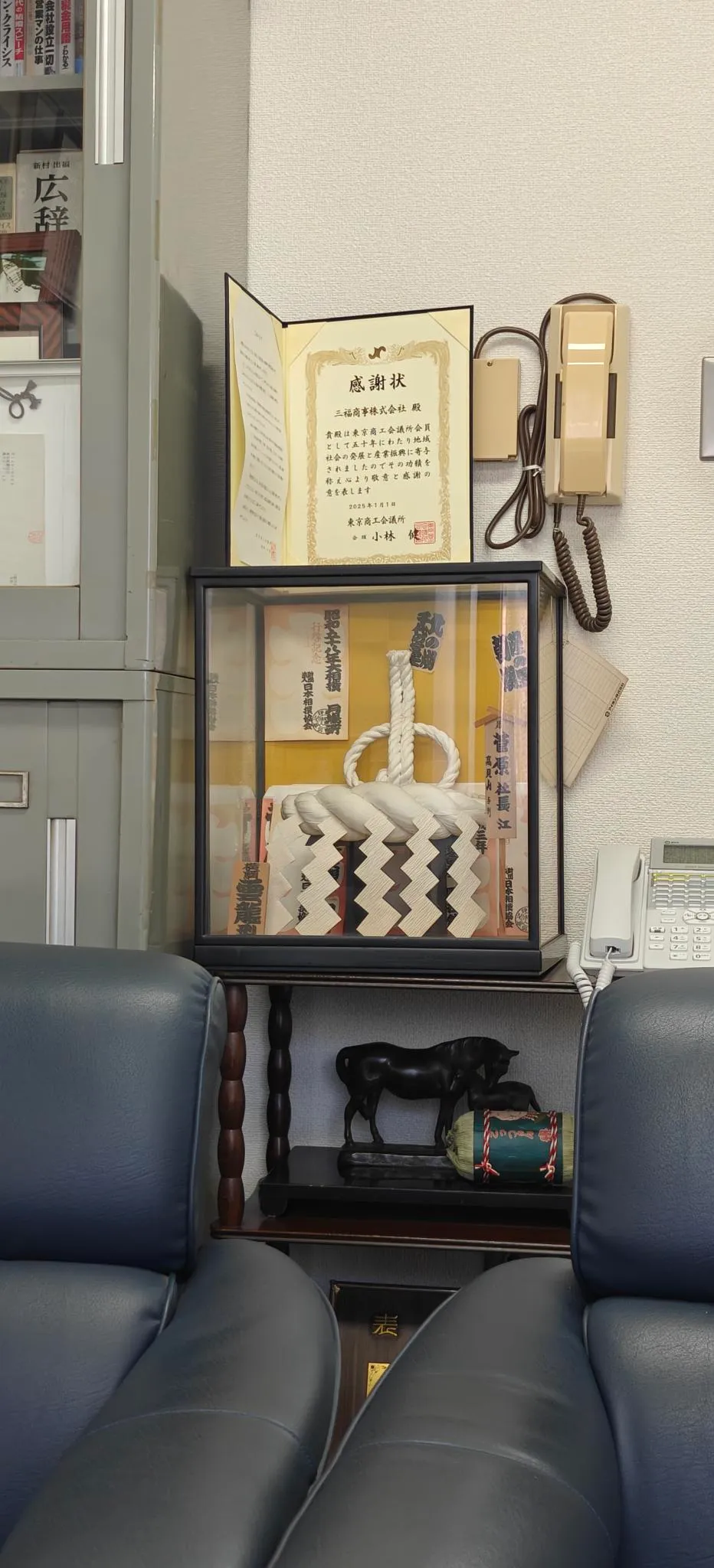 Dans un bureau, un petit cube de verre dans lequel on voit une tsuna